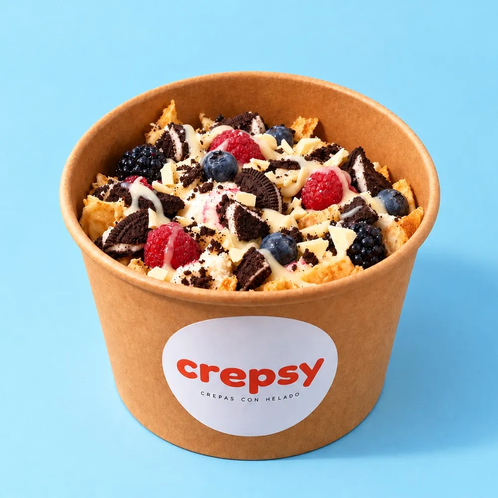 Bowl de papel con crepa y helado, galleta Oreo, frutos rojos, chocolate blanco y leche condensada en hilos